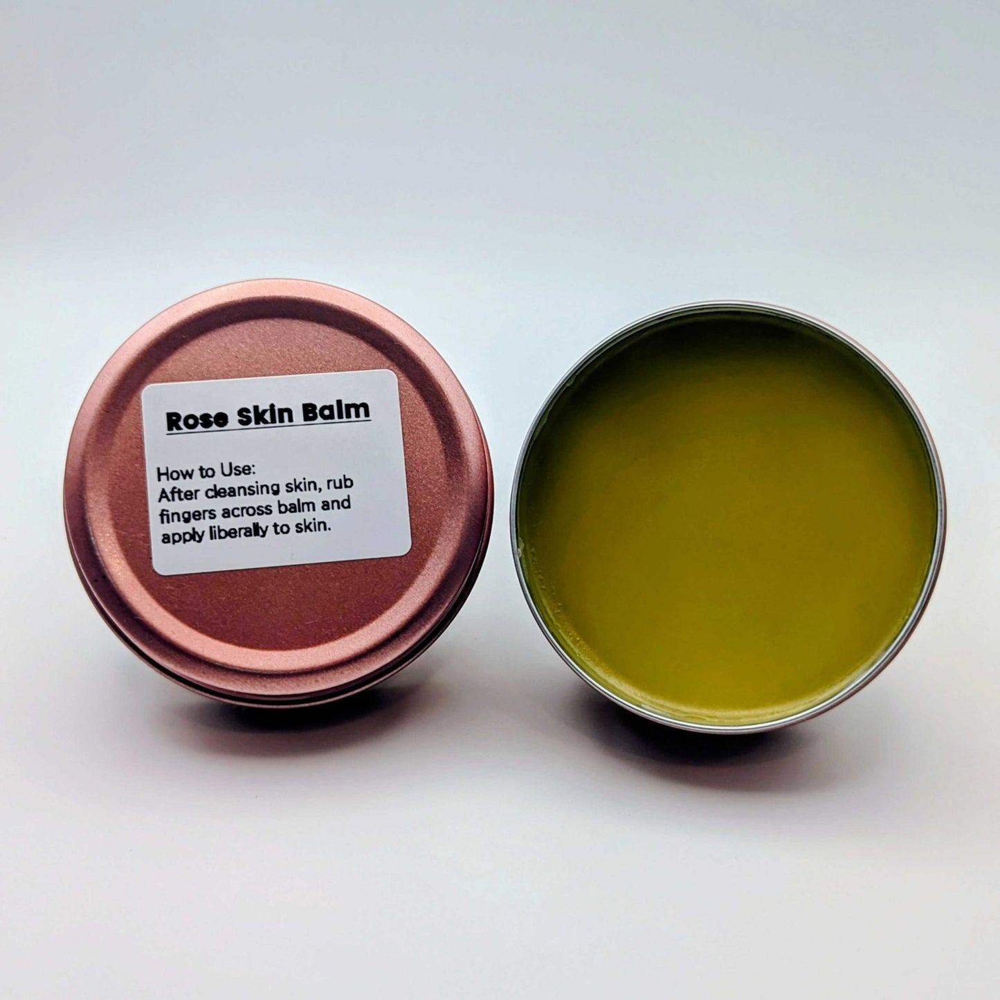 Rose Skin Balm in a metal tin with a label on a white background
