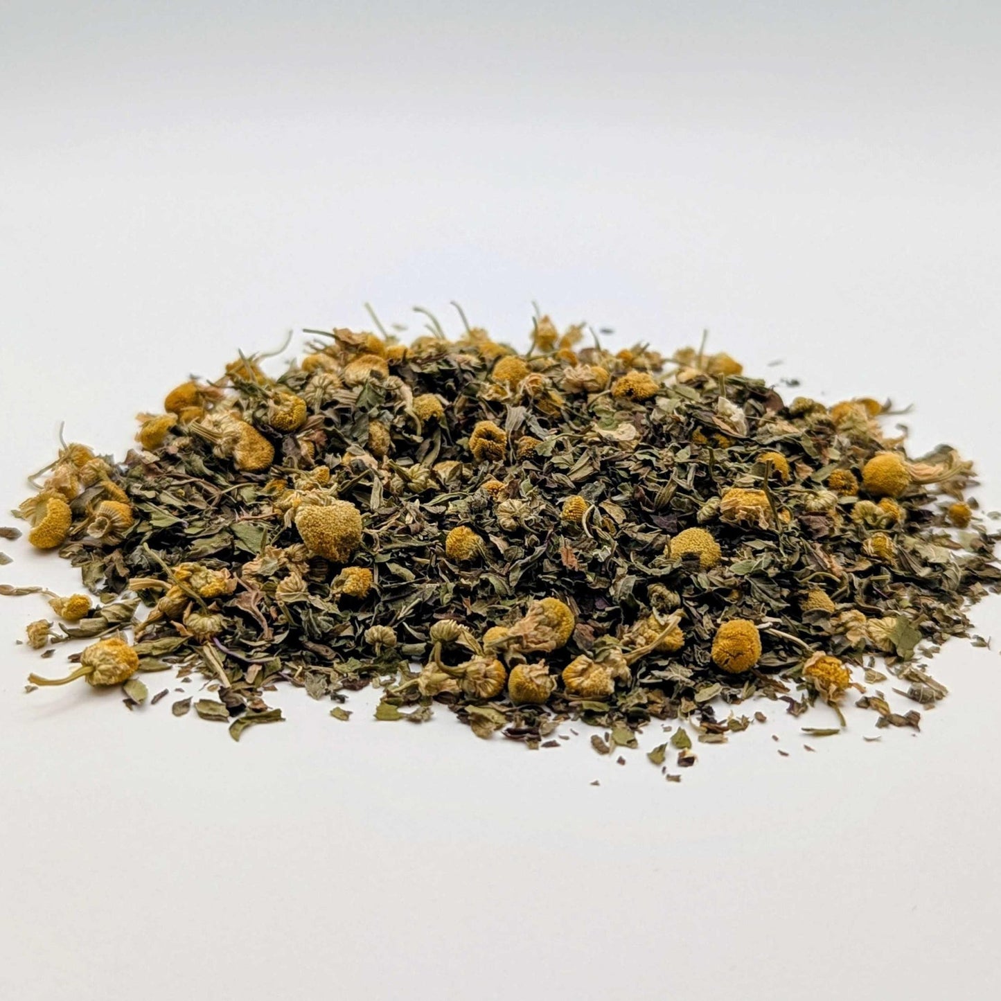 Heap of dried herbs with yellow flowers on a white background