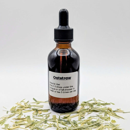 Bottle of Oatstraw tincture with dried oatstraw on a white background