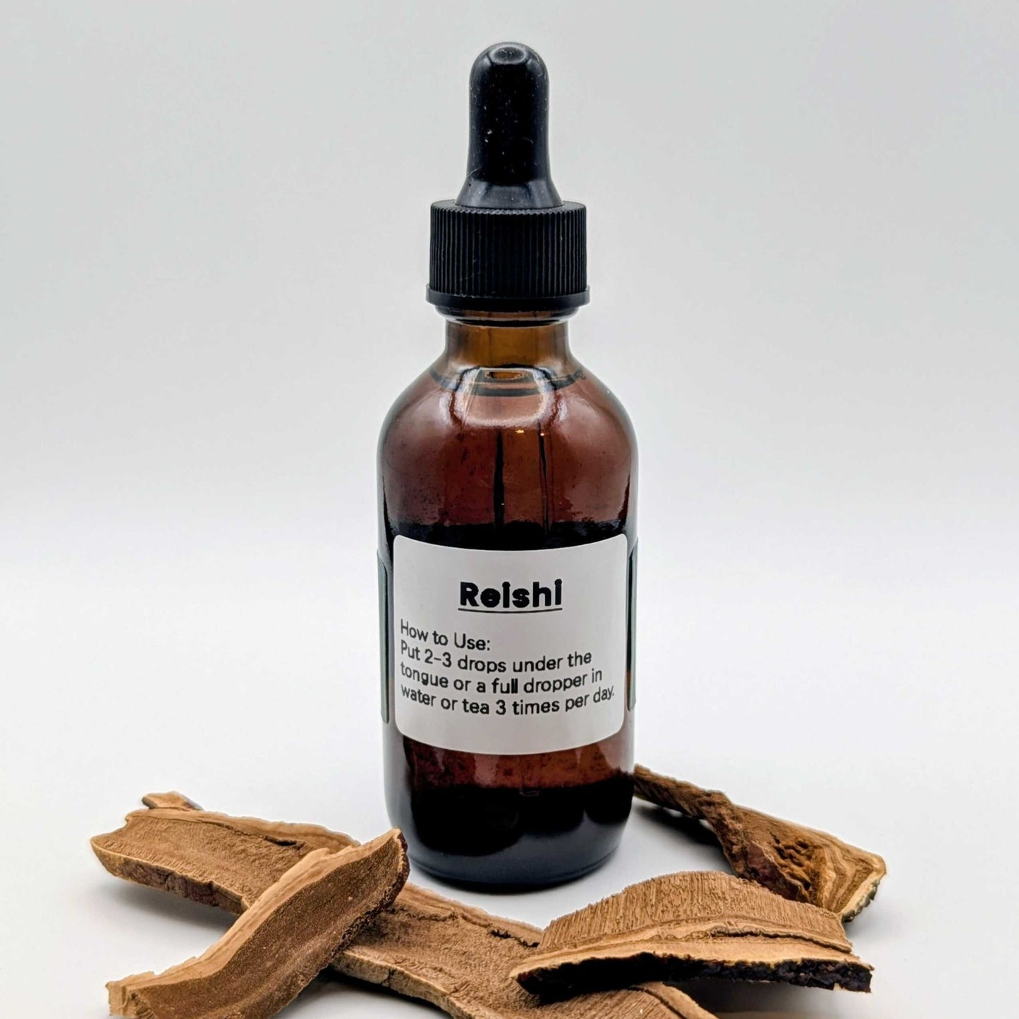 Bottle of Reishi liquid supplement with a wooden root on a white background