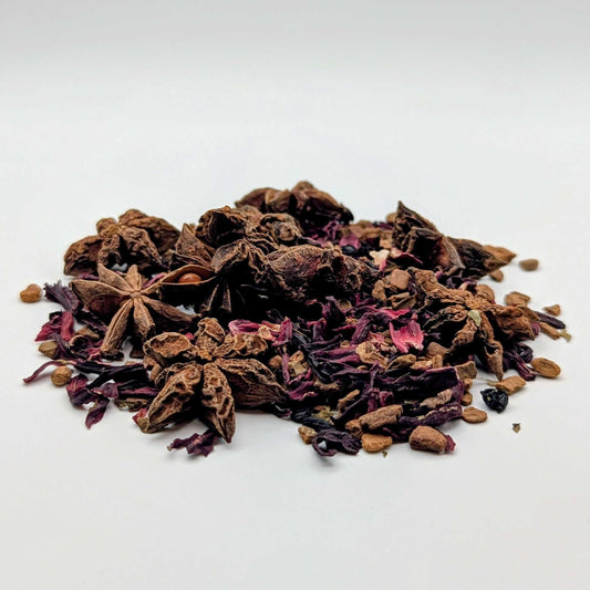 Spices including star anise and cloves on a white background