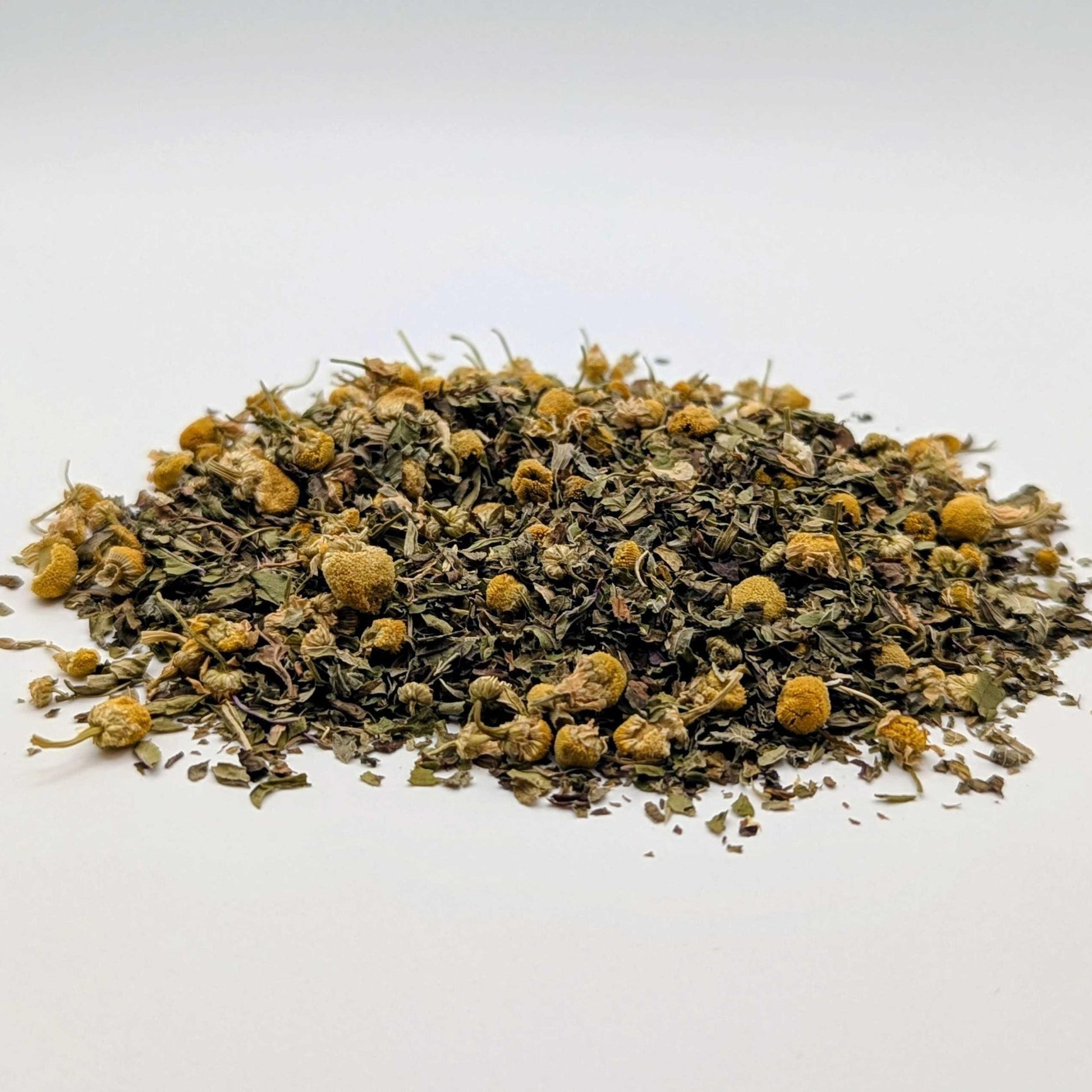 Heap of dried herbs with yellow flowers on a white background
